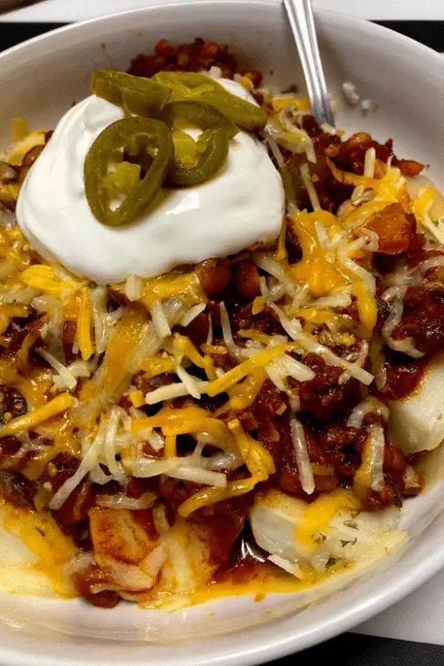 Sweet Heat Cowboy Chili with Shredded Cheese, Sliced Jalapeno, and Sour Cream on top