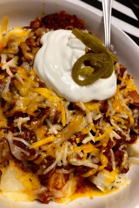 Sweet Heat Cowboy Chili with Shredded Cheese, Jalapeno Slices, and Sour Cream on top